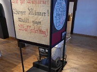 1896 beginnt der Aufbau der städtischen Wasserversorgung. Das klingt aus heutiger Perspektive gut. Doch damals formierte sich zunächst unter dem Motto "Brouche mer e Wasserleiring - mehr ho de Bomb verm Haus" Widerstand. Das zeigt auch das ausgestellte Tuch mir der Aufforderung, gegen den Bau der Wasserleitung zu stimmen. Trotz dieser Proteste wurde 1896 mit dem Bau begonnen. Die Alsfelder werden sich dann sicher schnell daran gewöhnt haben.