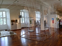 Blick in die Ausstellung: Spinninstallation und Leseecke mit Hörstationen
